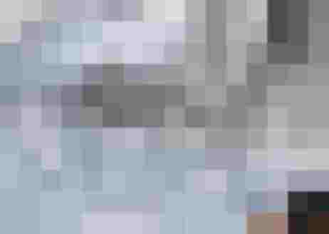 Winterlandschaft mit schneebedeckten Hügeln und im Hintergrund Häuser in Sankt Johann im Pongau.