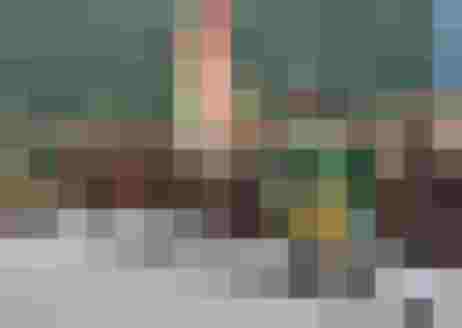 Traditionelle Trachtenträger mit Fahnen und Gewehren in einer festlichen Versammlung.